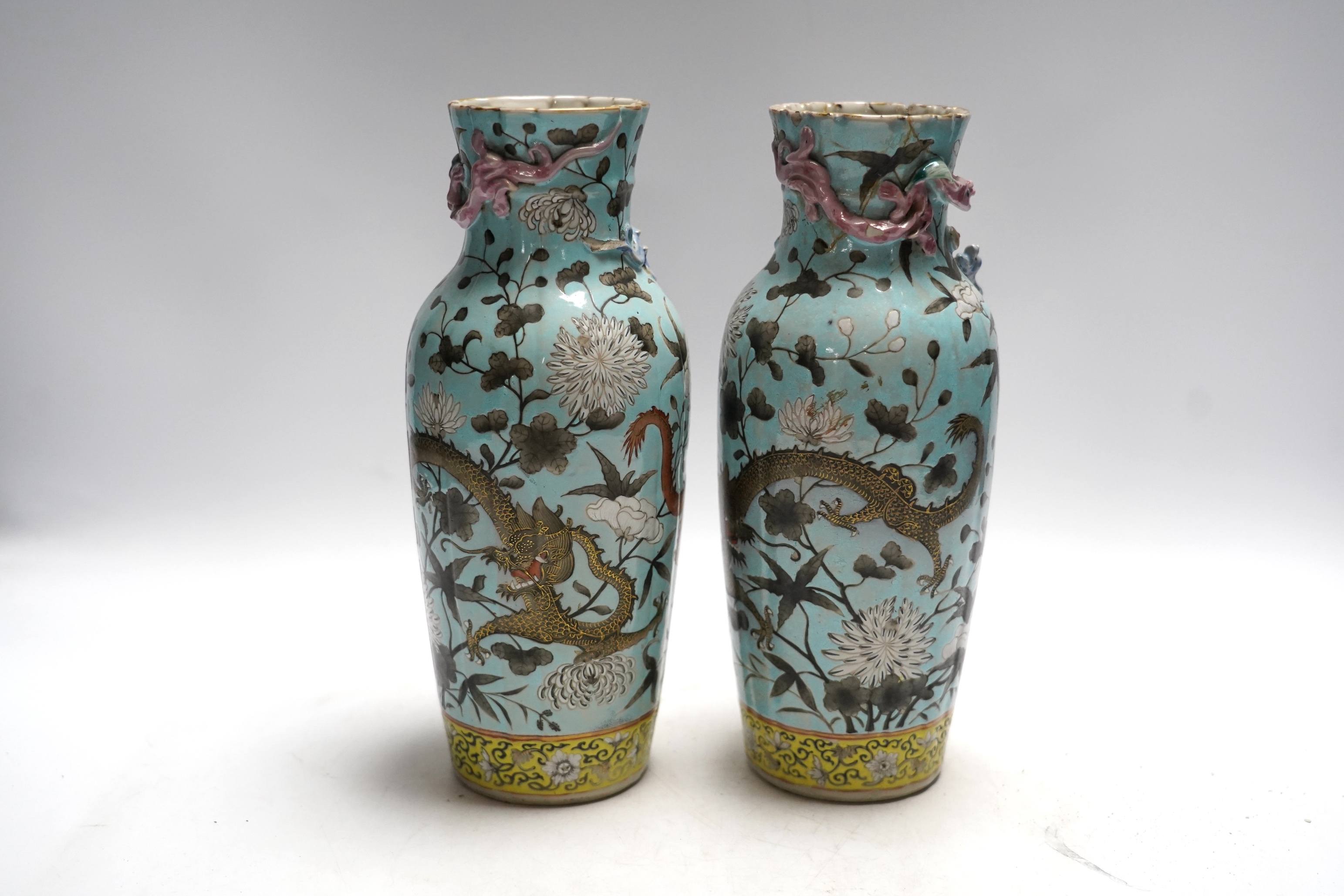 A pair of late 19th century Chinese blue glazed ‘dragon’ vases, 26cm high